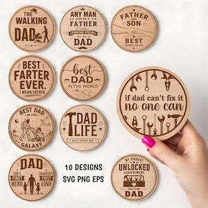 May include: Ten round wooden coasters with engraved designs and text, such as "The Walking Dad" and "Best Dad in the World." The coasters are made of light-coloured wood and feature various fonts and illustrations.