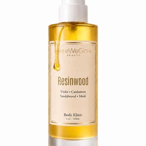 Close up of body oil pump showing lightweight fast absorbing texture, moisturizing woody body oil for dry skin non greasy glow oil.