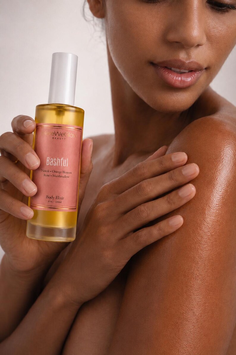 Model holding luxury body oil skincare ritual with glowing hydrated skin, feminine perfume body oil for soft radiant moisturized skin, non greasy fast absorbing body elixir for daily glow routines.