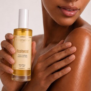 Woman applying hydrating body oil for glowing skin, non greasy woody musk perfume oil for soft radiant skin long lasting scent.