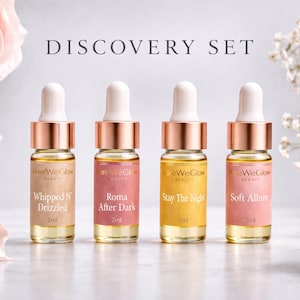 May include: A beauty product discovery set featuring four small glass bottles with dropper tops. Each bottle has a different colored label and contains a liquid. The text "DISCOVERY SET" is at the top, with floral accents.
