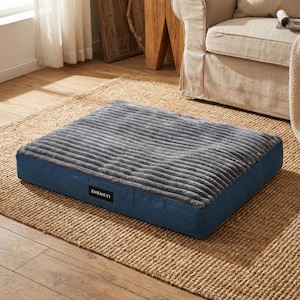 May include: A rectangular pet bed with a grey, corduroy-like top and blue sides. The bed has a label that reads "ZHENGYI". The bed is placed on a woven rug.