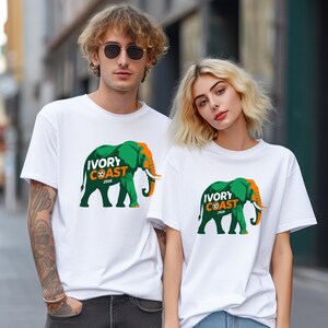 May include: White t-shirts with a green and orange elephant graphic and the text "IVORY COAST 2026". The elephant design is centered on the front of the shirts.