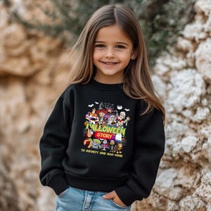 May include: A black long-sleeve sweatshirt featuring a colorful graphic print of various animated characters dressed in Halloween costumes. The text reads Halloween Story and To Infinity and Boo-Yond in bright yellow and green lettering.