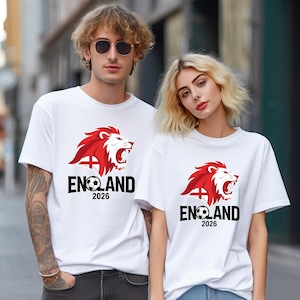 May include: White t-shirts with a red and white lion graphic, the word "ENGLAND", a football, and the year "2026" printed in black. The lion graphic has a red mane and a white face.