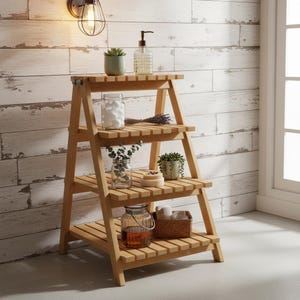 Peut inclure: Une étagère échelle en bois clair à trois niveaux avec un design à lattes. Les étagères contiennent divers objets, notamment un distributeur de savon en verre transparent, une petite plante succulente verte et un bocal en verre avec du coton.