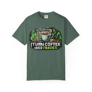 May include: Green t-shirt with a coffee-themed graphic. The design features a steaming coffee cup with the text "I Turn Coffee Into Trades" in a stylized font. The graphic includes green and brown accents.