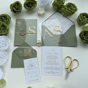 Convites de casamento de luxo em acrílico transparente: convite com detalhes em folha de ouro, envelope verde-sálvia, cartão com informações e confirmação de presença por QR Code.