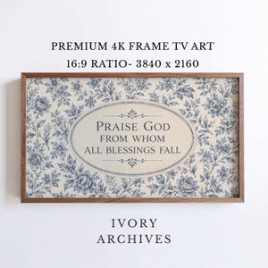 May include: A framed art print with a floral pattern in blue and cream. The text "PRAISE GOD FROM WHOM ALL BLESSINGS FALL" is centered within an oval. The frame is a dark wood color. The words "IVORY ARCHIVES" are at the bottom.