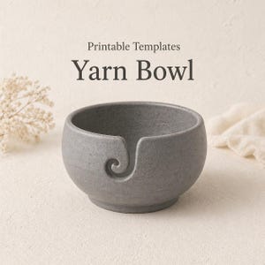 Può includere: Una ciotola per filato grigia con un disegno a spirale sul lato. La ciotola ha una forma arrotondata e una fessura per tenere il filato. Il testo "Printable Templates" e "Yarn Bowl" sono visualizzati sopra la ciotola.