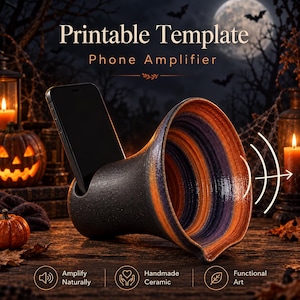 May include: A ceramic phone amplifier with a black exterior and a purple and orange interior. The device features a slot for a smartphone and is labeled with the text Printable Template Phone Amplifier, Amplify Naturally, Handmade Ceramic, and Functional Art.
