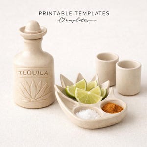 Puede incluir: Una botella de tequila de cerámica beige con un tapón en forma de sombrero, la palabra "TEQUILA" está grabada en la parte delantera. Una fuente de cerámica contiene gajos de lima, sal y especias. También hay dos vasos de chupito pequeños.