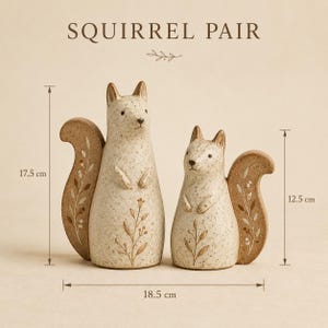 May include: A pair of cream-colored squirrel figurines with brown speckled details and floral patterns on their tails. The text SQUIRREL PAIR is visible above. Dimensions are 17.5 cm and 12.5 cm in height, with a total width of 18.5 inches.