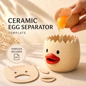 以下が含まれることがあります： ひびの入った卵の形をした、アヒルの顔のデザインのセラミック卵セパレーター。卵黄がセパレーターに注がれています。「CERAMIC EGG SEPARATOR」と「TEMPLATE」の文字が見えます。