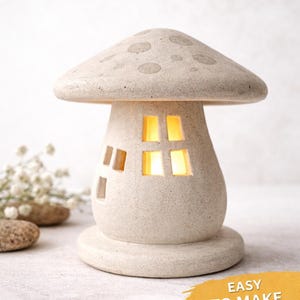 May include: A beige mushroom-shaped ceramic house with a dotted cap and rectangular windows that glow with warm light. The text "Mushroom House" is at the top, with "Easy to Make" and "Digital Download" at the bottom.