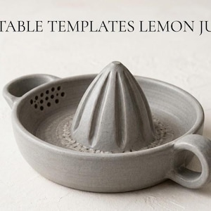 Op de afbeelding: Een grijze keramische citroenpers met een geribbelde ruimer en twee handvatten. De pers heeft een komvorm met een tuit en kleine gaatjes. De tekst "PRINTABLE TEMPLATES LEMON JUICER" staat bovenaan.