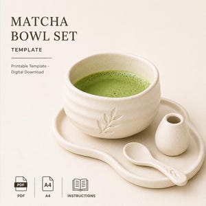 Puede incluir: Un juego de cuencos de matcha de cerámica beige claro, que incluye un cuenco con té matcha verde, un platillo, una jarrita y una cuchara. El cuenco y la cuchara tienen diseños de hojas. El texto "Matcha Bowl Set" está en la parte superior.