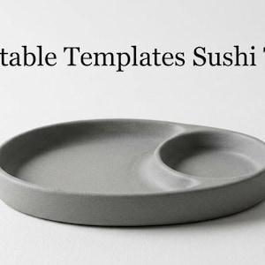 Op de afbeelding: Een grijs, ovaalvormig sushiblad met een kleiner, afgerond compartiment. De tekst "Printable Templates Sushi Tray" wordt boven het blad weergegeven. Het blad is gemaakt van een mat materiaal en staat op een witte ondergrond.