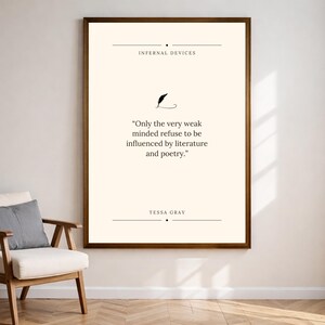 Peut inclure: Une affiche encadr&eacute;e avec un fond cr&egrave;me et un cadre marron fonc&eacute;. Le texte indique "INFERNAL DEVICES" au-dessus d'une illustration de plume et une citation de Tessa Gray : "Seuls les esprits faibles refusent d'&ecirc;tre influenc&eacute;s par la litt&eacute;rature et la po&eacute;sie."