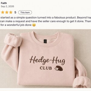 May include: A light pink crewneck sweatshirt featuring dark brown embroidery on the chest. The text reads Hedge-Hug CLUB, accompanied by a small embroidered graphic of a hedgehog. The garment has long sleeves with ribbed cuffs and a ribbed neckline.
