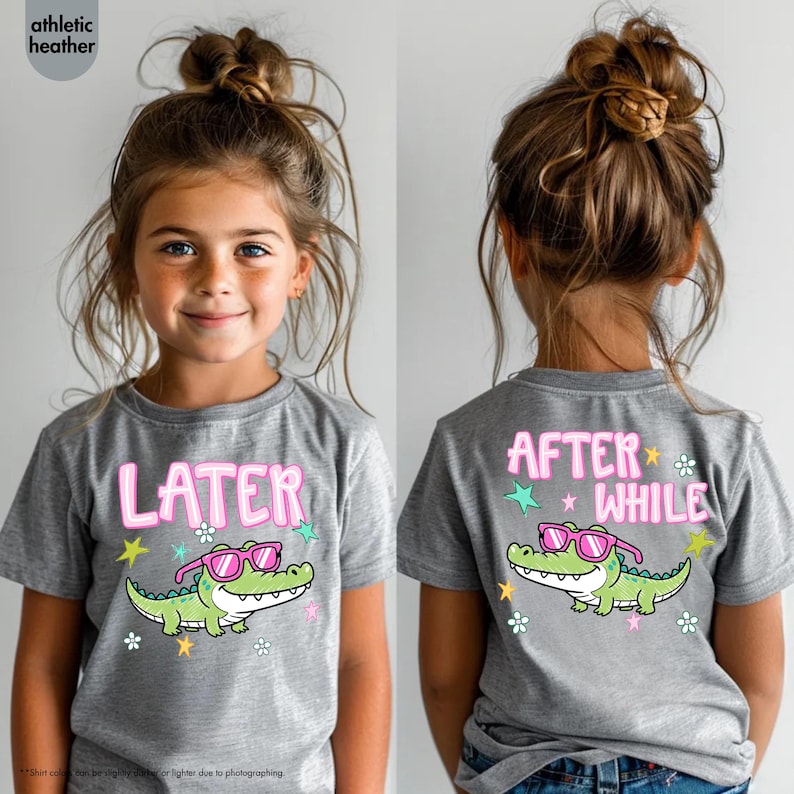 May include: Athletic heather gray t-shirt with a cartoon alligator wearing pink sunglasses. The front of the shirt says "LATER" in pink letters. The back of the shirt says "AFTER WHILE" in pink letters.