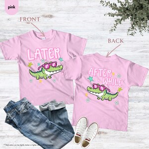 May include: Two pink t-shirts with a cartoon alligator wearing sunglasses. The front shirt says "LATER" and the back says "AFTER WHILE". The shirts are paired with blue jeans and white sneakers.
