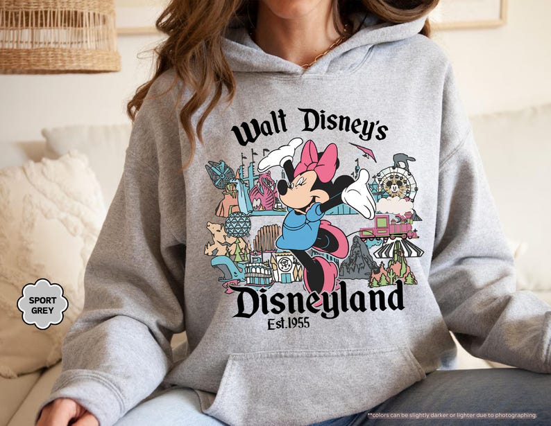 Pu&ograve; includere: Felpa grigio sportiva con Minnie Mouse e la scritta "Walt Disney's Disneyland Est.1955". Il design include varie attrazioni di Disneyland. La felpa ha una tasca frontale e un cappuccio con coulisse.