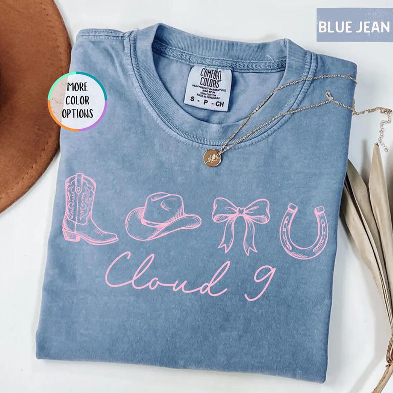 May include: A white ceramic mug with a black handle and the text "But First, Coffee" in a bold, black font. The mug is set against a blurred background, suggesting a cozy setting.