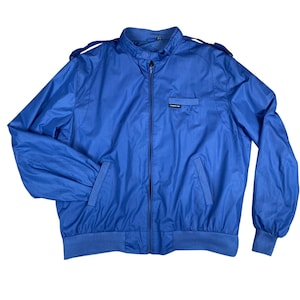 Pode incluir: Casaco Members Only azul brilhante com gola alta, fecho frontal e dois bolsos frontais. O casaco tem bainha e punhos canelados e ombreiras. O logótipo da marca é visível no bolso do peito.