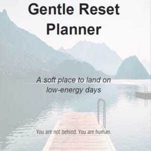 May include: A planner cover with the text "Gentle Reset Planner" against a backdrop of a lake and mountains. The text "A soft place to land on low-energy days" and "You are not behind. You are human." are also visible.