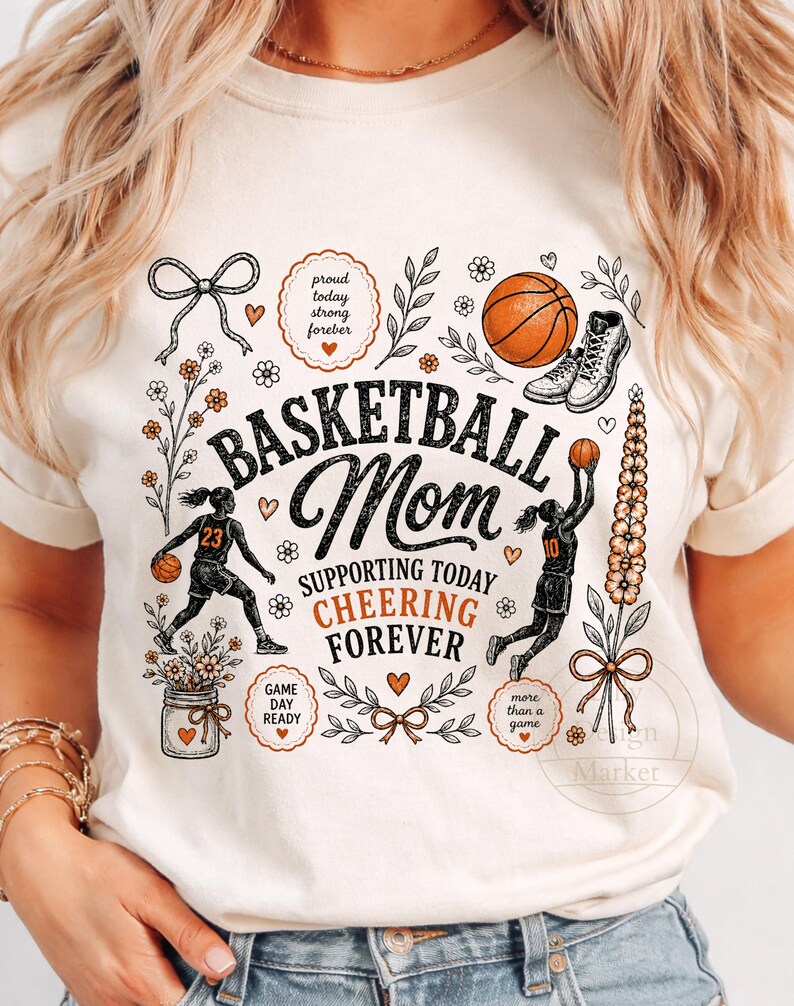 Puede incluir: Camiseta de color crema con un gr&aacute;fico tem&aacute;tico de baloncesto. El dise&ntilde;o incluye las palabras "Basketball Mom" con texto de apoyo e ilustraciones de baloncesto. La camiseta presenta una pelota de baloncesto, zapatillas y detalles florales.