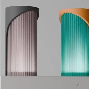 May include: Two contemporary lamps. One has a grey top and a pink, vertically-lined body. The other has an orange top and a teal, vertically-lined body. Both lamps are on a white surface.