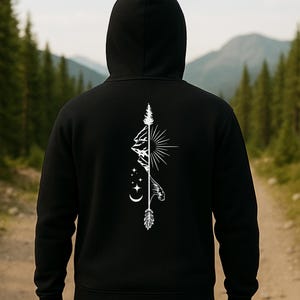 May include: Black hooded sweatshirt with a white graphic design on the back. The design features a mountain range, sun, stars, and an arrow. The sweatshirt is made of a soft material and has a drawstring hood.
