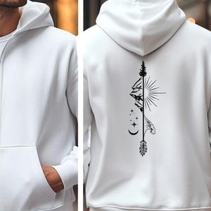 May include: White zip-up hoodie with a front pocket and a hood. The back features a black graphic design of a mountain, sun, stars, and an arrow. The hoodie is made of a soft, comfortable material.