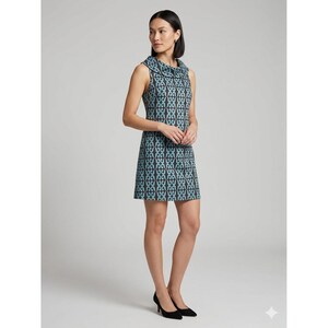 May include: A sleeveless mini dress featuring a cowl neckline and a repeating geometric pattern in light blue and dark charcoal gray. The dress has a straight silhouette that falls above the knee, constructed with a structured fabric finish.