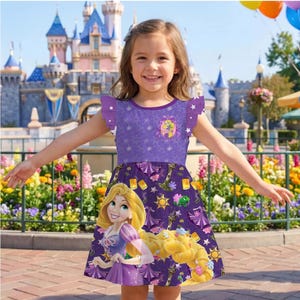 May include: A purple dress featuring a cartoon image of Rapunzel. The dress has a purple bodice with a round neckline and ruffled sleeves. The skirt has a repeating pattern of Rapunzel, lanterns, and suns. The background shows a castle and flowers.