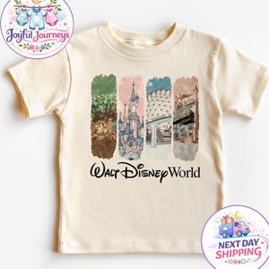 Puede incluir: Camiseta crema para ni&ntilde;os peque&ntilde;os con un gr&aacute;fico colorido de los monumentos de Walt Disney World. El dise&ntilde;o incluye im&aacute;genes de un castillo y otras atracciones, con las palabras "Walt Disney World" en escritura negra.