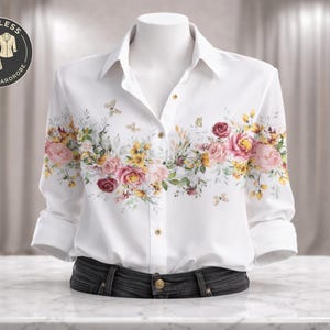 May include: White button-down shirt with a floral design featuring pink and yellow roses, butterflies, and green leaves. The shirt is displayed on a mannequin with rolled-up sleeves and dark denim jeans. The logo reads "Timeless Classic Wardrobe."