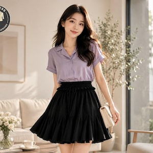 Peut inclure: Une femme porte une chemise à col courte à manches courtes violet clair et une jupe noire à volants. Elle porte un sac à main crème avec une chaîne dorée. Le logo circulaire indique "TIMELESS CLASSIC WARDROBE".