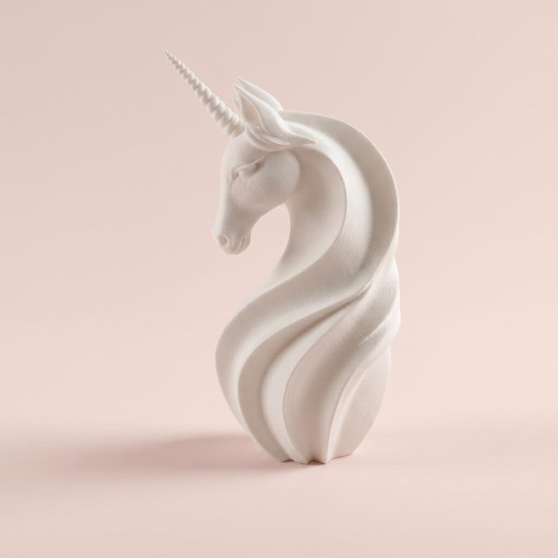 May include: A white unicorn sculpture with a spiraling mane and a detailed, textured horn. The sculpture is set against a soft pink background, highlighting its elegant form and design. The unicorn's head is gracefully curved.