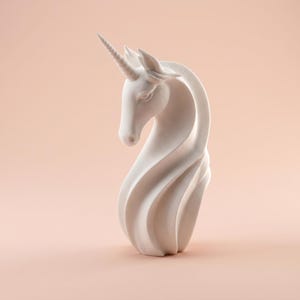 May include: A white unicorn sculpture with a spiraling neck and a textured horn. The sculpture is set against a soft peach background, highlighting its elegant form. The unicorn's head is gracefully positioned, showcasing its detailed features.