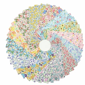 Pode incluir: Uma disposição circular de quadrados de tecido, cada um com um padrão floral único. Os tecidos apresentam uma variedade de cores, incluindo rosa, amarelo, azul e verde, criando uma exibição vibrante e colorida. Ideal para projetos de patchwork e artesanato.