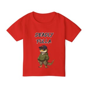 May include: Red t-shirt with the text "DEADLY FULLA" above an illustration of a lizard wearing a hoodie, sunglasses, and a cap. The lizard is in khaki shorts and has a patterned tail.