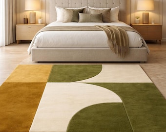 May include: A modern bedroom with a large bed, two bedside tables with lamps, and a geometric rug. The rug features a mustard yellow, olive green, and cream color block design. The bed has a neutral-toned headboard and bedding.