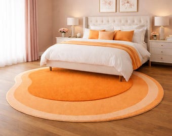 May include: A bedroom with a white bed, orange accents, and a round rug. The bed has white linens, orange pillows, and a matching throw. The rug is a vibrant orange with lighter orange and cream borders. The room has a chandelier and two framed floral prints.
