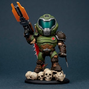 Puede incluir: Figura detallada de un personaje con armadura verde, sosteniendo un arma con detalles en naranja y una cuchilla roja. La figura se apoya sobre una base con varias calaveras blancas. El personaje tiene un casco verde con visera.