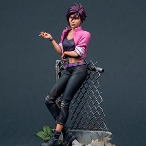 May include: A figurine of a person with short purple hair, wearing a pink jacket, black top, and ripped black jeans. They are leaning against a chain-link fence, holding a cigarette. The figure is posed on a stone base with debris.