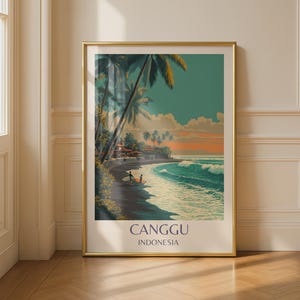 May include: A framed art print depicting a beach scene with palm trees, ocean waves, and a sunset. The print includes the text "CANGGU INDONESIA" at the bottom. The frame is gold, and the artwork is displayed on a wooden floor.