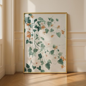Könnte beinhalten: Ein gerahmter botanischer Druck mit einer Aquarellillustration von Kletterpflanzen mit weißen und orangefarbenen Blüten und grünen Blättern. Das Kunstwerk ist vor einem cremefarbenen Hintergrund in einem goldfarbenen Rahmen.