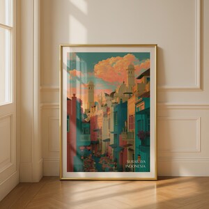 Könnte beinhalten: Ein vertikaler Kunstdruck in einem goldenen Rahmen, der eine Straßenszene in Surabaya, Indonesien, darstellt. Die Illustration zeigt farbenfrohe Gebäude in Rosa-, Türkis- und Gelbtönen unter einem Sonnenuntergangshimmel. Der Text Surabaya Indonesia ist sichtbar.